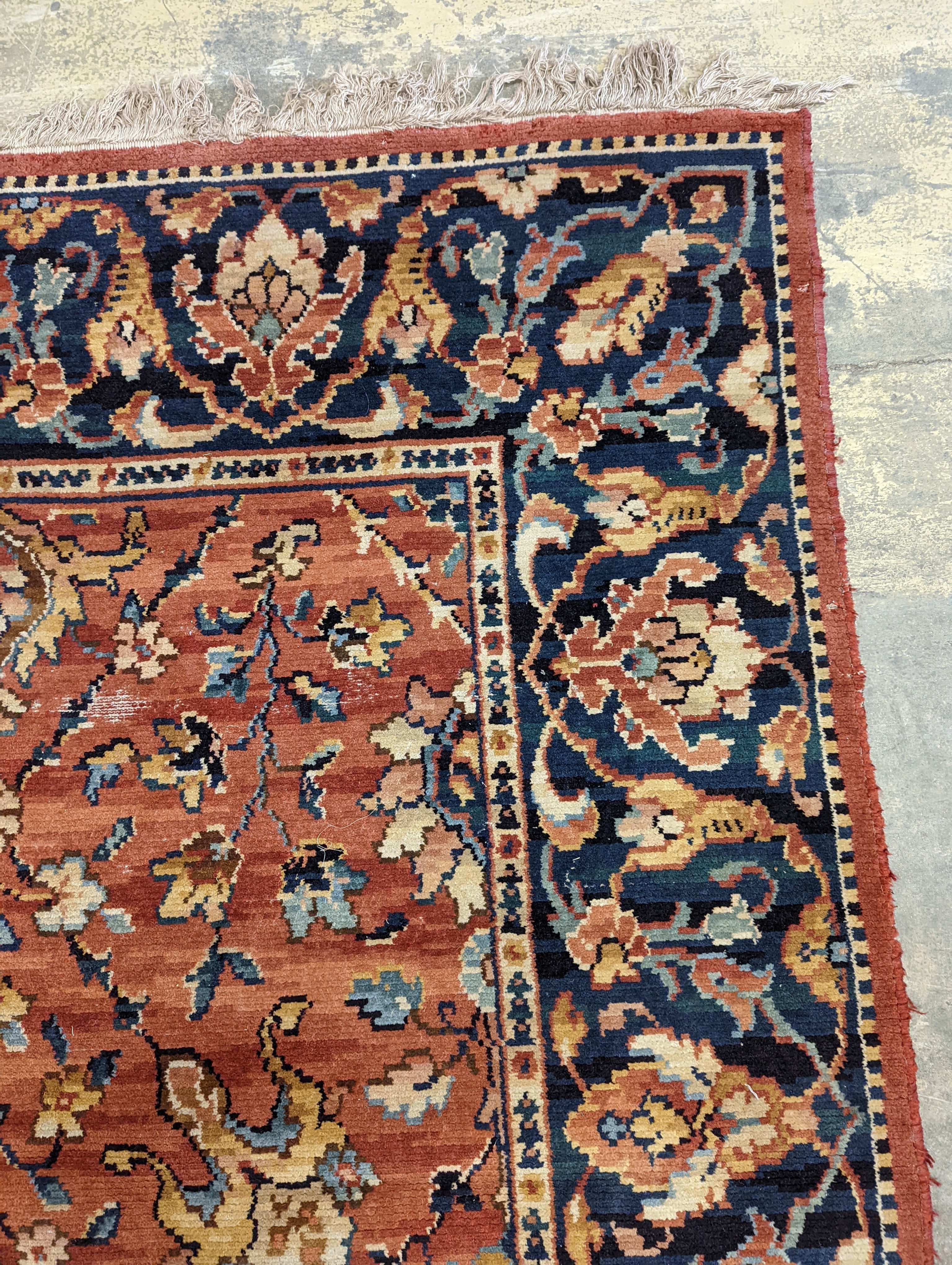 A Persian style machined brick red ground carpet (severely worn), 392 x 286cm